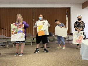 Showing off art work at I AM ME: A Day of Self-Advocacy and Empowerment held in August 2022.